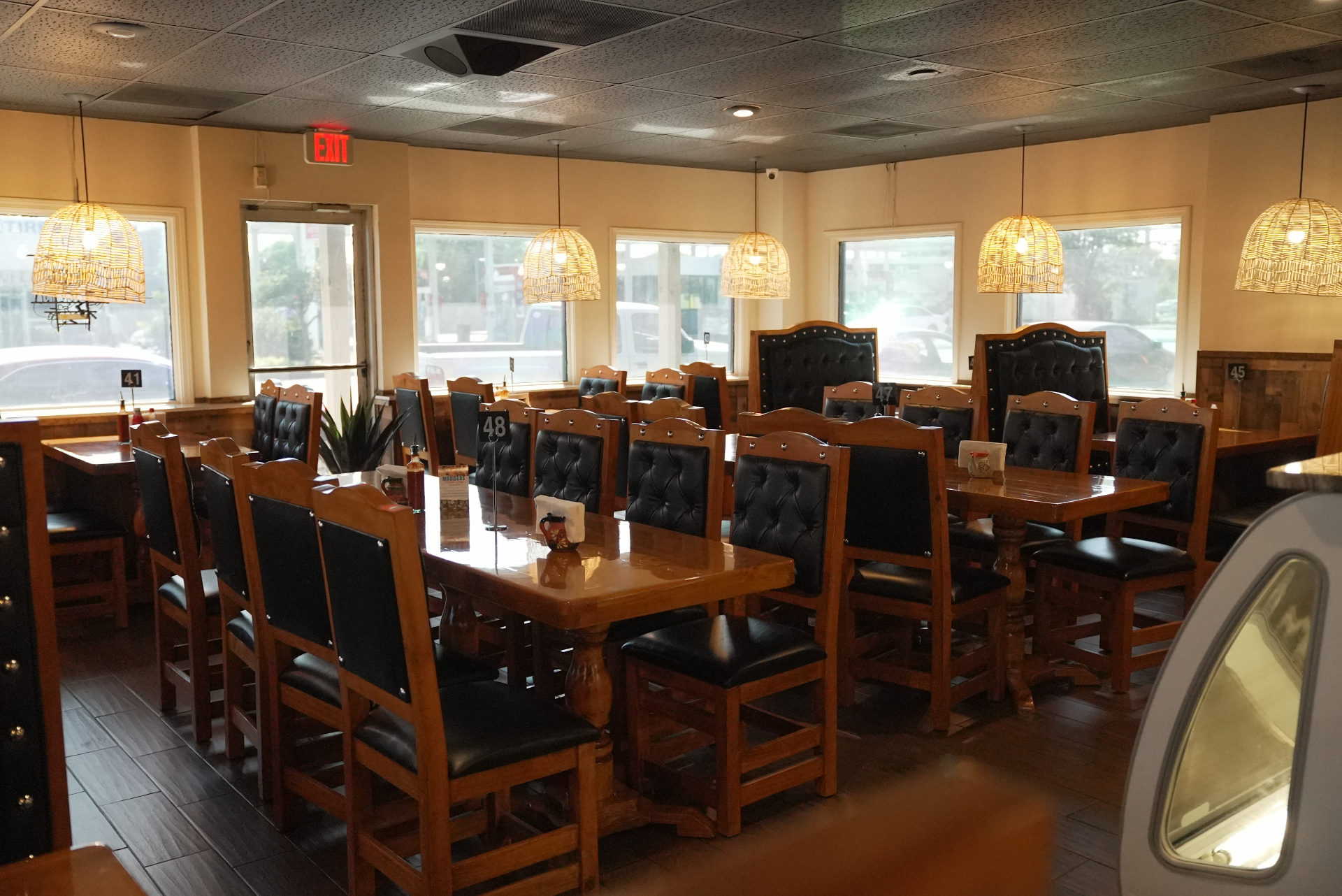 Sunlit dining room with long wooden tables at Chela's